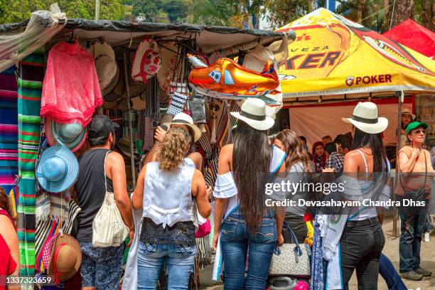 fiesta in san francisco, cundinamarca in the south american country of colombia - young colombian ladies seen buying hats - cundinamarca stock pictures, royalty-free photos & images