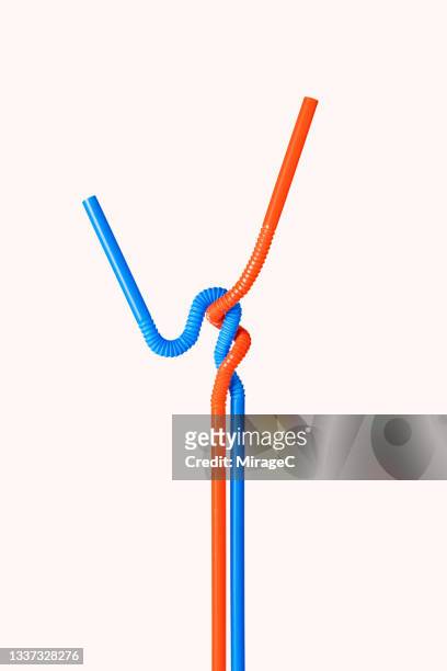 two intertwined drinking straws - relazione simbiotica foto e immagini stock