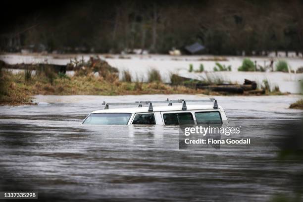 Vehicle is submerged in the Kumeu River as heavy rain causes extensive flooding and destruction on August 31, 2021 in Auckland, New Zealand. Many...