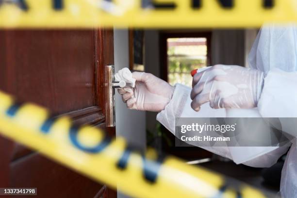 close-up tiro de um trabalhador irreconhecível em um traje de proteção limpando uma maçaneta em uma área isolada - white suit - fotografias e filmes do acervo