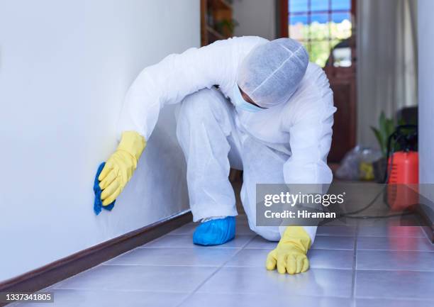 foto de un hombre con un traje de materiales peligrosos limpiando una pared para desinfectar una casa - crime scene cleaners fotografías e imágenes de stock