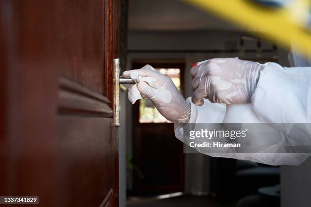 primer plano de un trabajador irreconocible con un traje protector limpiando un pomo de la puerta en un área acordonada - crime scene cleaners fotografías e imágenes de stock