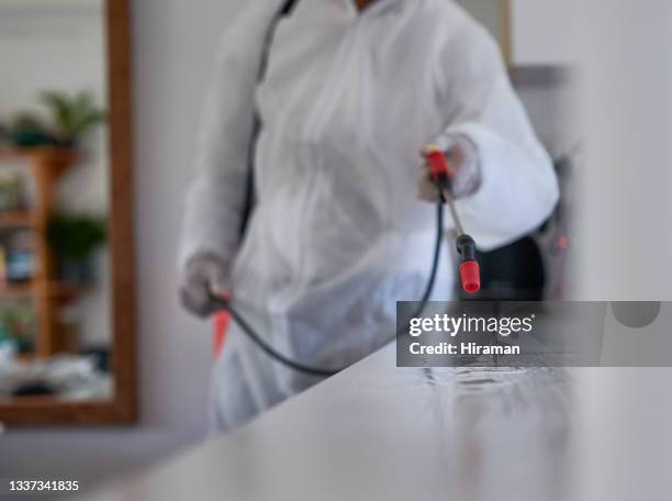 primer plano de un limpiador irreconocible que usa un pulverizador químico para desinfectar una superficie en una casa - crime scene cleaners fotografías e imágenes de stock