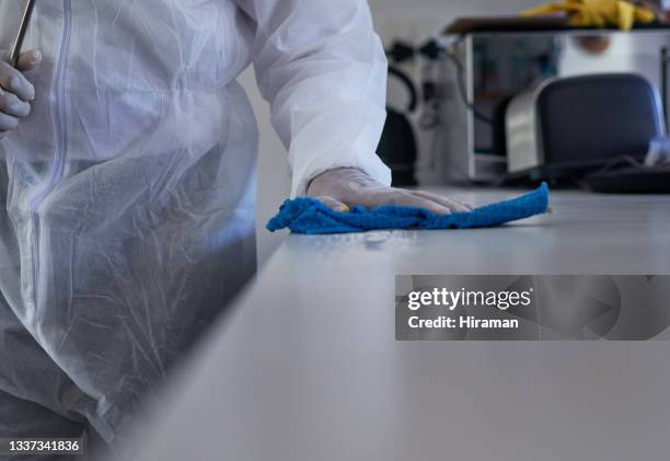 nahaufnahme eines nicht erkennbaren reinigers, der eine oberfläche in einem haus abwischt - biogefährliche substanz stock-fotos und bilder