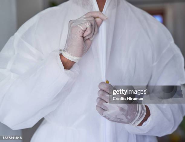 primer plano de un hombre irreconocible abriendo un traje de materiales peligrosos - mono blanco traje protector fotografías e imágenes de stock