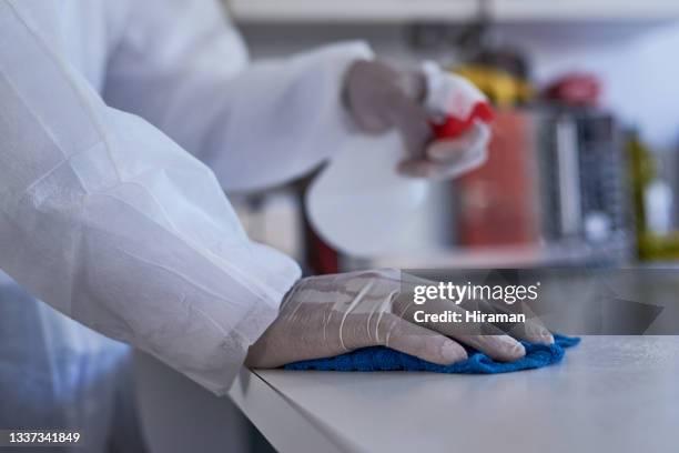 closeup shot of an unrecognisable cleaner wiping a surface in a house - vod stockfoto's en -beelden