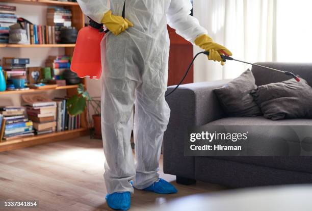 primer plano de un hombre irreconocible en un traje de materiales peligrosos usando un pulverizador químico para desinfectar una casa - crime scene cleaners fotografías e imágenes de stock