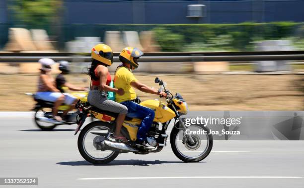 motorcyclist is seen walking down the street - 4 wheel motorbike stock pictures, royalty-free photos & images