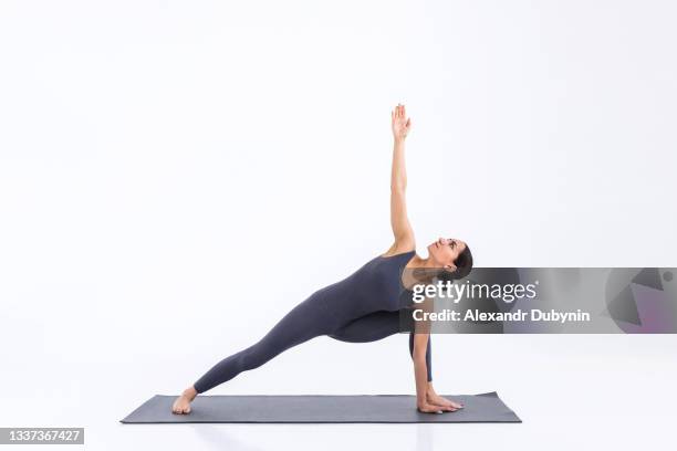 yogi woman practicing yoga on mat on white background in studio - upright position stock pictures, royalty-free photos & images