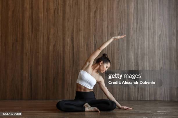 yogi woman practicing yoga in the gym while sitting on the floor - upright position stock pictures, royalty-free photos & images