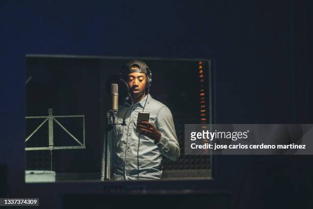 african american man, rapper, with cap recording in a booth, recording studio - radio dj photos et images de collection