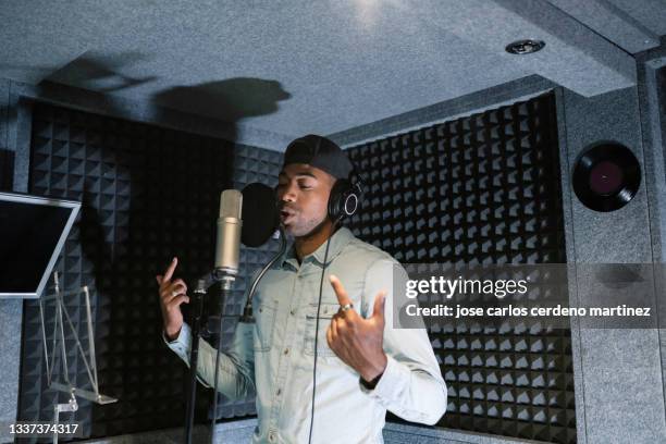 young african american male rapper, songwriter recording song in studio - musician male energy stock-fotos und bilder