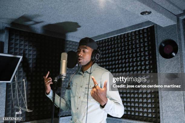 young african american male rapper, songwriter recording song in studio - musician male energy imagens e fotografias de stock