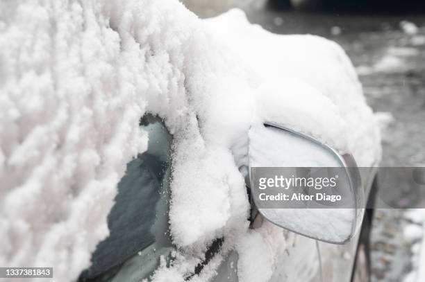 rearview mirror and car window covered with snow after a heavy snowfall in winter. berlin, germany. - snow melting on car stock pictures, royalty-free photos & images