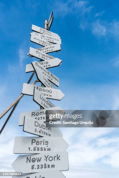 travel destinations signpost at cape finisterre - kilometer stockfoto's en -beelden