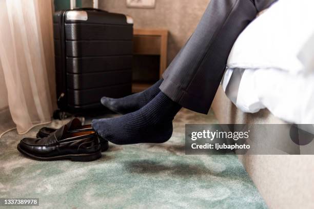 foto eines geschäftsmannes im hotelzimmer beim sitzen und entspannen - black men feet stock-fotos und bilder