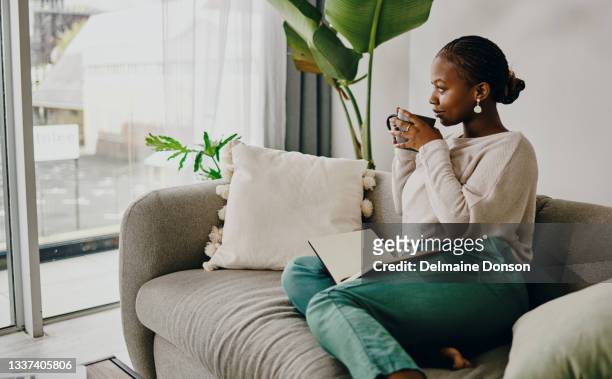 shot of a young woman relaxing on the couch at home - diário imagens e fotografias de stock