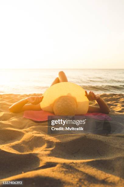 junge frau beim sonnenbaden am strand - protection luxe stock-fotos und bilder