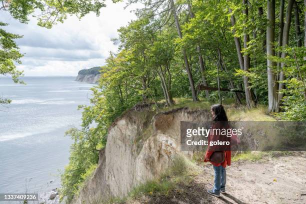 frau schaut von der kreidefelsküste auf der insel rügen - rügen island chalk cliffs stock-fotos und bilder