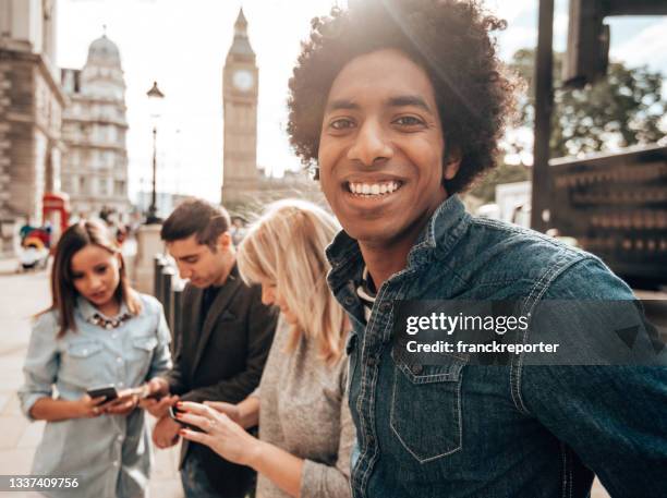 lächelnde freunde, die spaß in london haben - london und umgebung stock-fotos und bilder