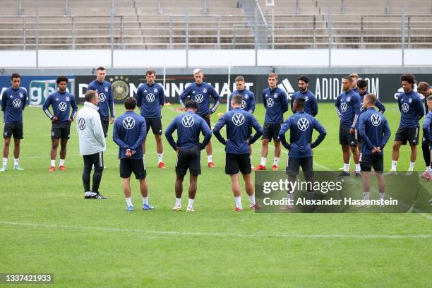 Hans-Dieter Flick, Head Coach of Germany talks to his player during a training session at Gazi-Stadion auf der Waldau on August 31, 2021 in...