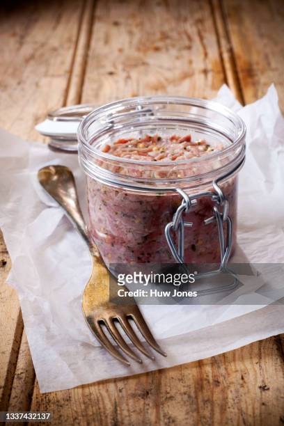 potted pork rillettes, in a glass jar on white parchment paper - frances jones fotografías e imágenes de stock