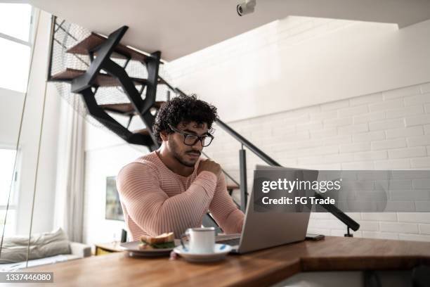 young man using laptop at home - bodybuilder-laptop stock pictures, royalty-free photos & images