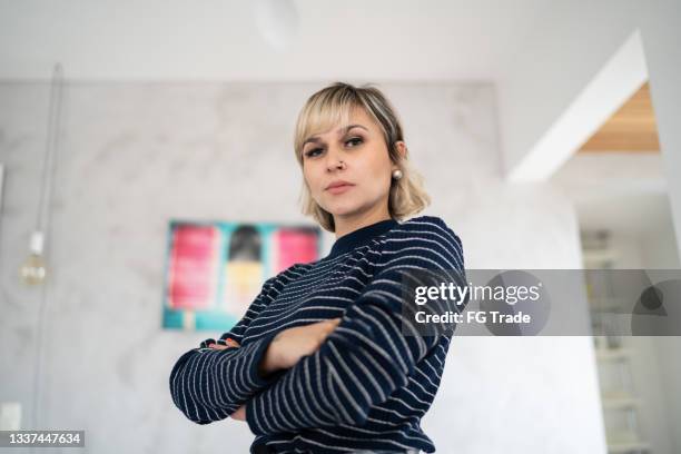 porträt einer ernsten mittel erwachsenen frau zu hause - arms crossed woman stock-fotos und bilder