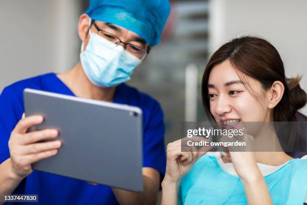 dentist examining teeth of female patient - reliability stock pictures, royalty-free photos & images