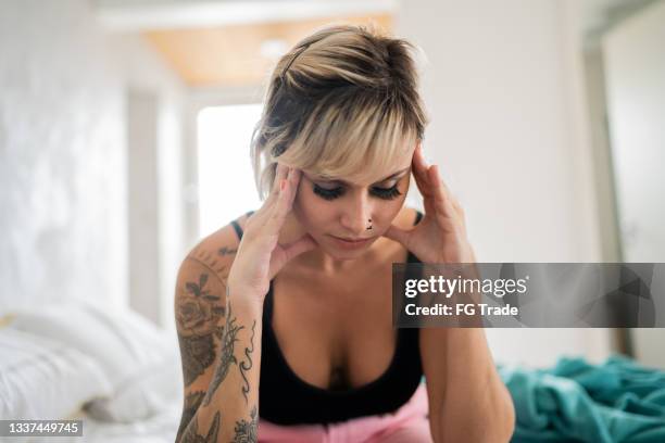 woman waking up with headache at home - hangover headache stock pictures, royalty-free photos & images