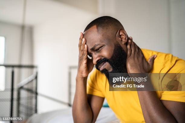 man waking up with headache at home - one mistake stock pictures, royalty-free photos & images