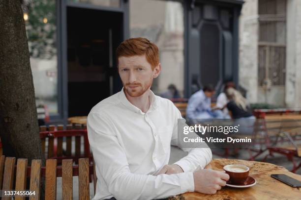 portrait of the young redhead businessman on the terrace - enjoying coffee cafe morning light stock pictures, royalty-free photos & images