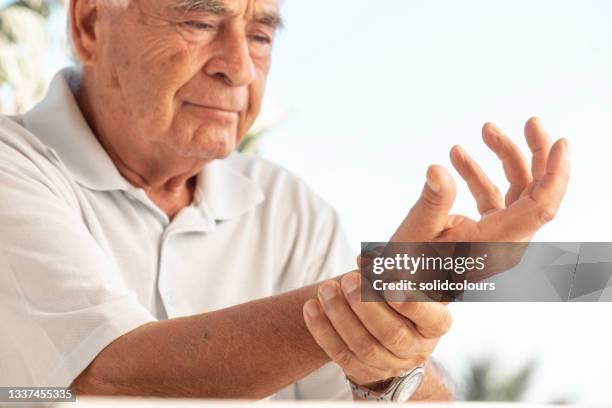 senior man trinkwasser - arthritis hands stock-fotos und bilder