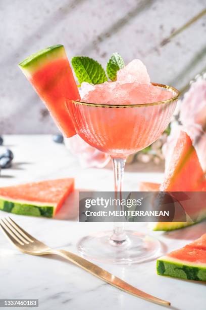 watermelon granita glass cup on marble table with watermelon slices - sorbetto stockfoto's en -beelden