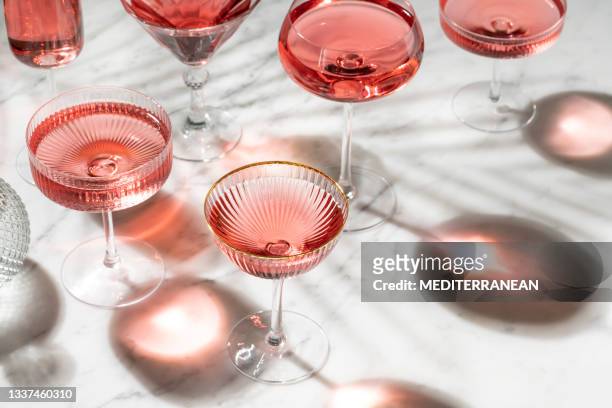 pink rose cocktail oder mocktail mit sonnigem sommerlicht auf weißem marmor - drink stock-fotos und bilder