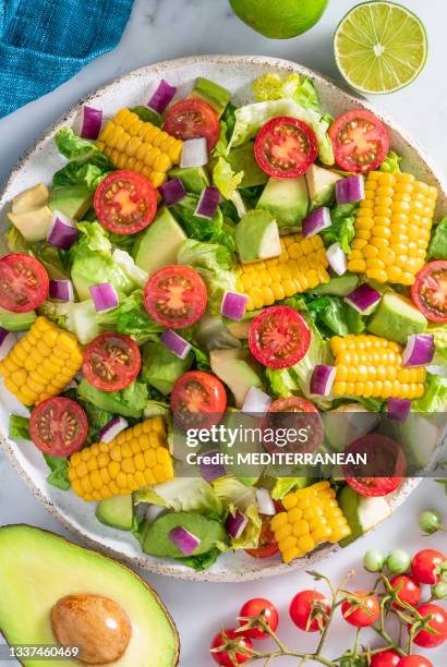 ensalada de tomate de maíz y aguacate ensalada vegana saludable sobre mármol blanco con ingredientes - avocato oil fotografías e imágenes de stock