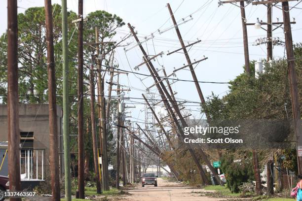 Utility poles lean over a street following Hurricane Ida on August 31, 2021 in Houma, Louisiana. Ida made landfall August 29 as a Category 4 storm...