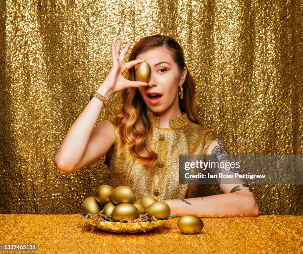 beautiful woman holding golden eggs over eyes - golden egg stock pictures, royalty-free photos & images