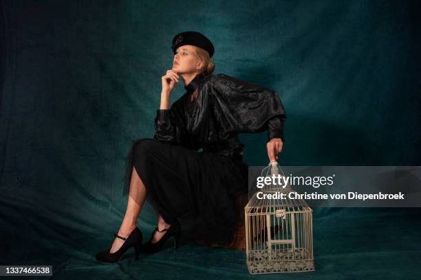 young woman old fashioned with bird cage - lady bird film stock-fotos und bilder