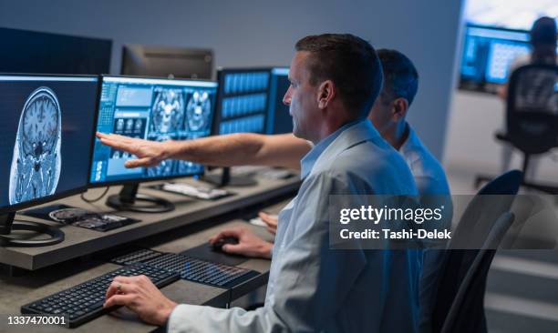 doctors working with computer and analyzing medical scans - ct röntgen bildbanksfoton och bilder