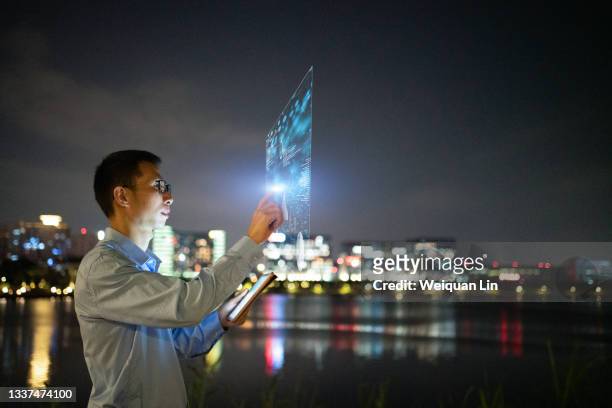 asians use virtual reality screens for touch operations at night - shenzhen stock pictures, royalty-free photos & images