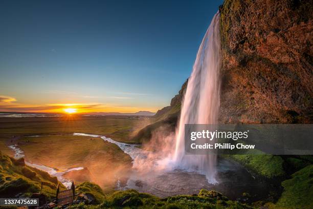 iceland seljalandsfoss waterfall midnight sun - sole di mezzanotte foto e immagini stock