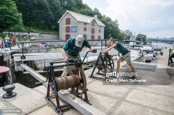 woman and man manually opening the gate of the ottawa canal locks - ottawa locks stock pictures, royalty-free photos & images