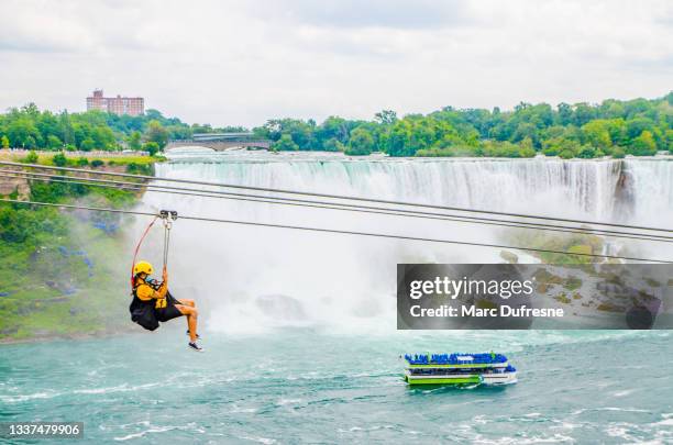 frau, die vor den niagarafällen die zipline hinuntergeht - niagara falls canada stock-fotos und bilder