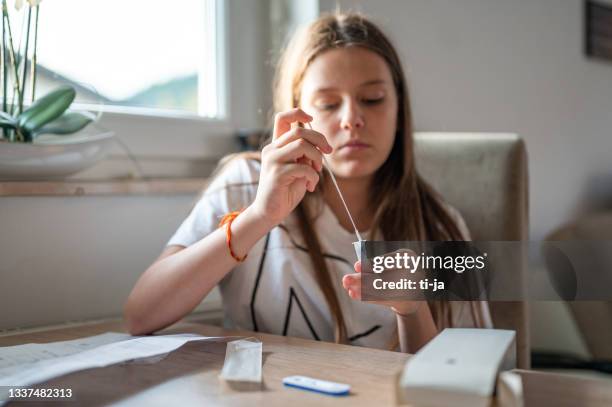 young girl doing a covid self-testing - coronavirus slovenia stock pictures, royalty-free photos & images