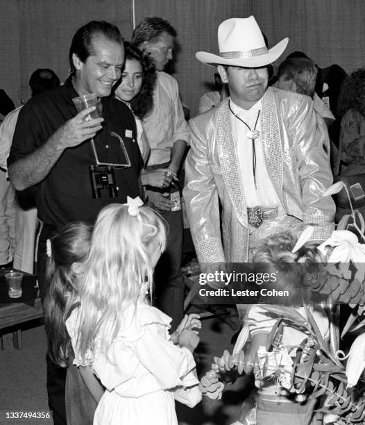 American actor and filmmaker Jack Nicholson and English singer, songwriter, pianist and composer Sir Elton John laugh backstage during Elton's 1984...