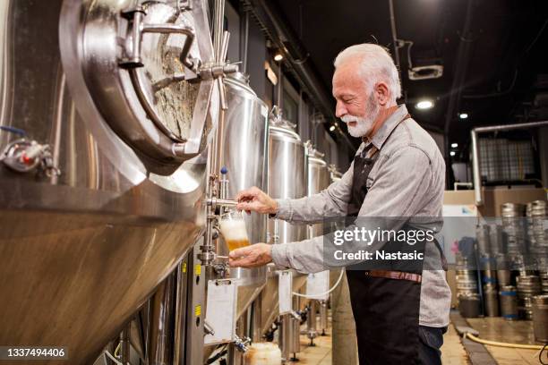 pouring a glass of beer at brewery plant - microbrewery stock pictures, royalty-free photos & images