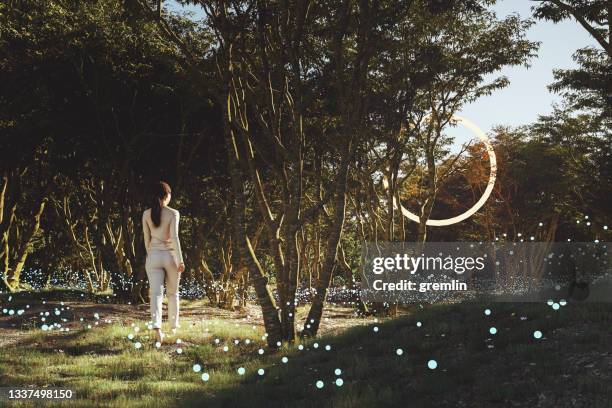 frau im wald, die auf ein mysteriöses objekt zugeht - magic doors stock-fotos und bilder