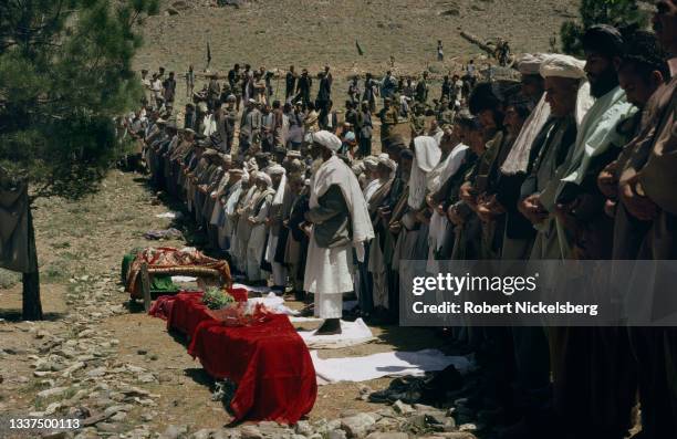 Mourners attend the funeral ceremony of five children, Kabul, Afghanistan, May 11, 1988. The children had been playing soccer when they were killed,...