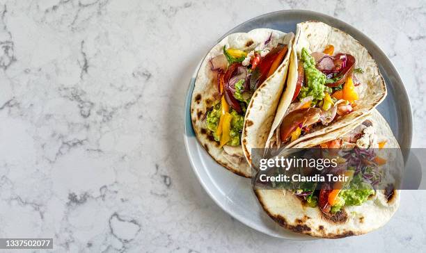 fresh tacos on a plate on white, marble background - tortilla stock-fotos und bilder